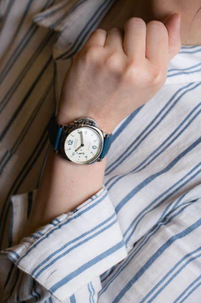 The white dial fake watch has a blue strap.